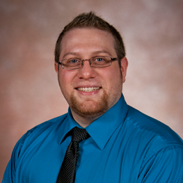 A man in a blue shirt and a neck tie